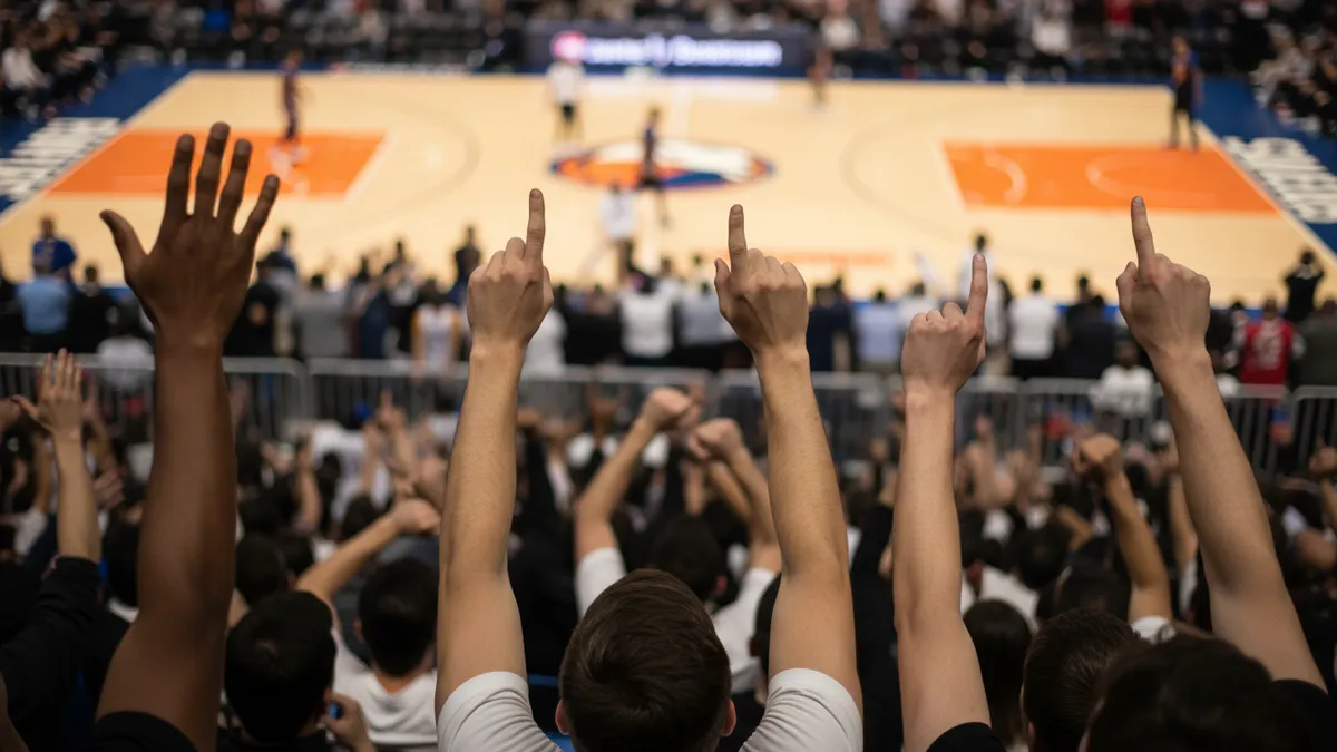 Manos de aficionados levantadas en un partido de la NBA