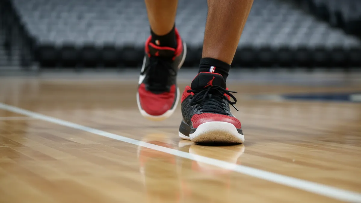 Zapatillas de baloncesto sobre la línea de la cancha en un primer plano.