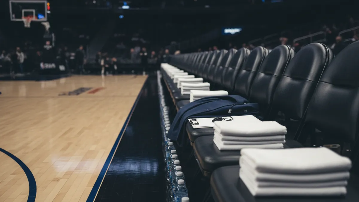 Banco de la NBA con toallas y botellas de agua, al atardecer.